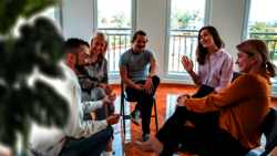 Eine Gruppe sitzt in der Runde und diskutiert