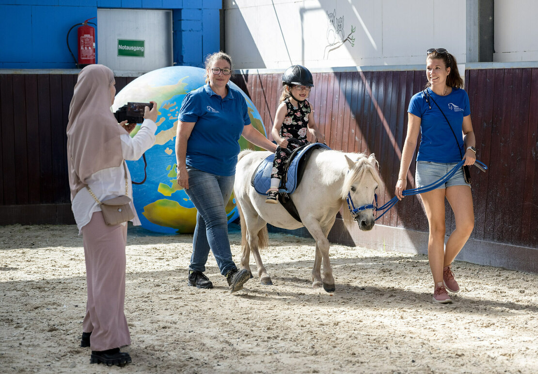 Ein Mädchen beim geführten Reiten auf einem Pony