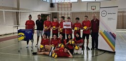 Gruppenfoto eines Volleyballteams mit einem Plakat von Aktion Mensch