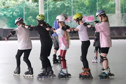 Fünf Mädchen fahren hintereinander in einer Reihe Inline Skate