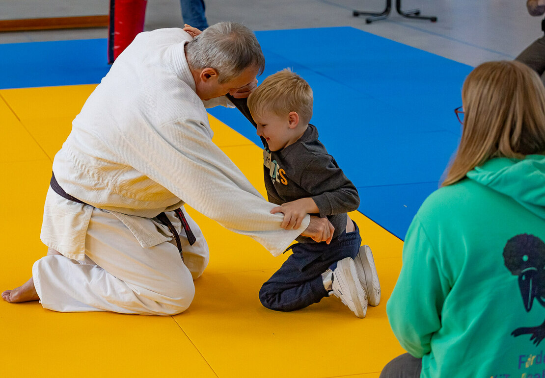 Ein kleiner Junge beim Karatetraining mit einem Trainer